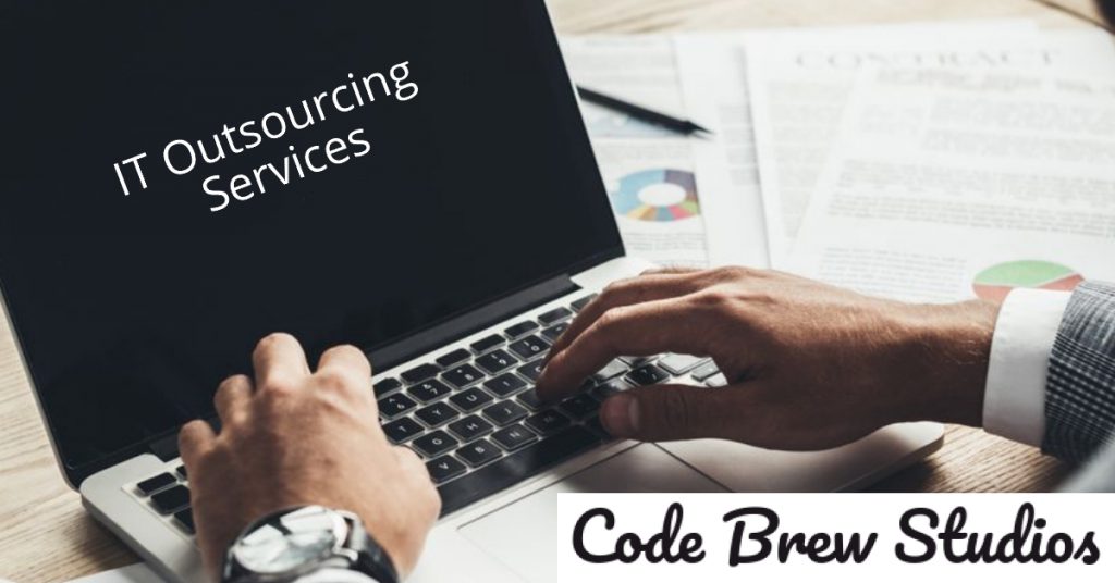 Laptop with IT Outsourcing Services written on the screen.